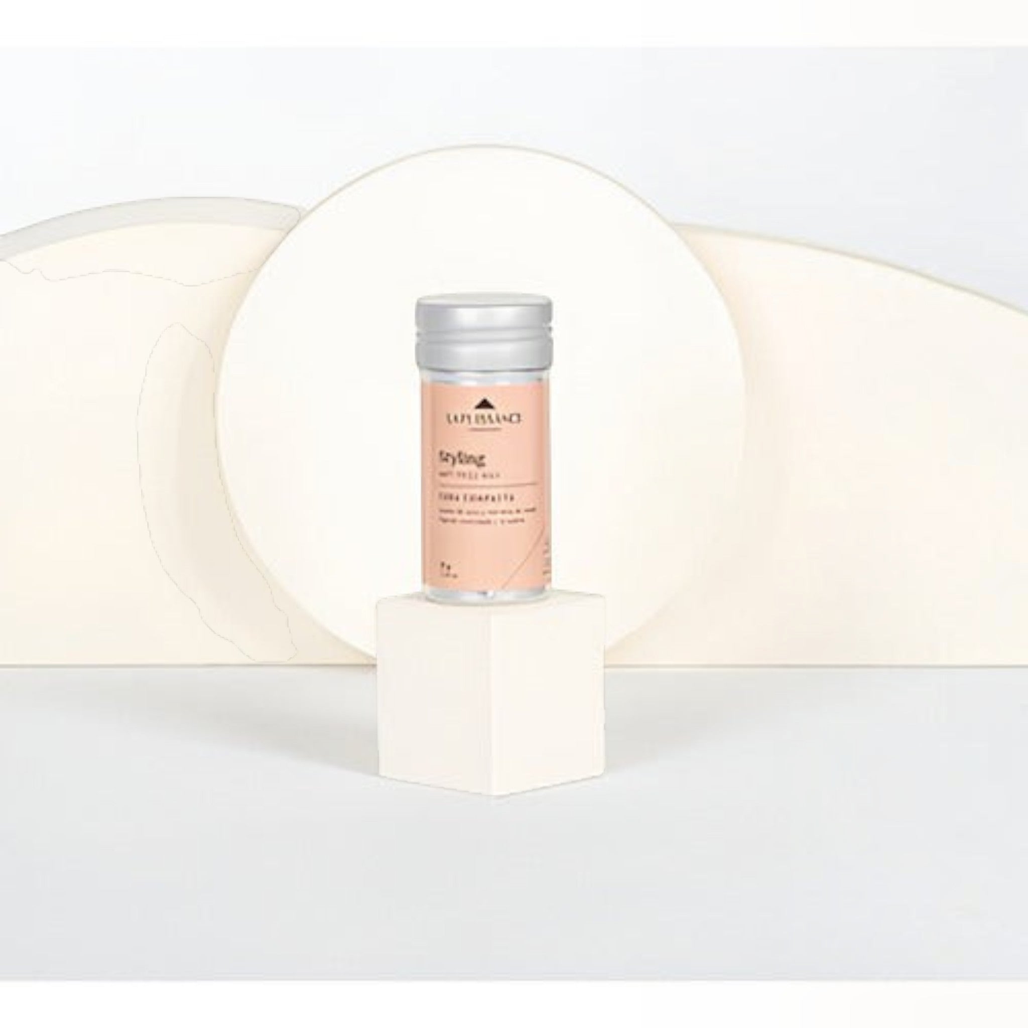 Cera modeladora antifrizz La Puissance de Distriwil en envase cilíndrico sobre pedestal blanco