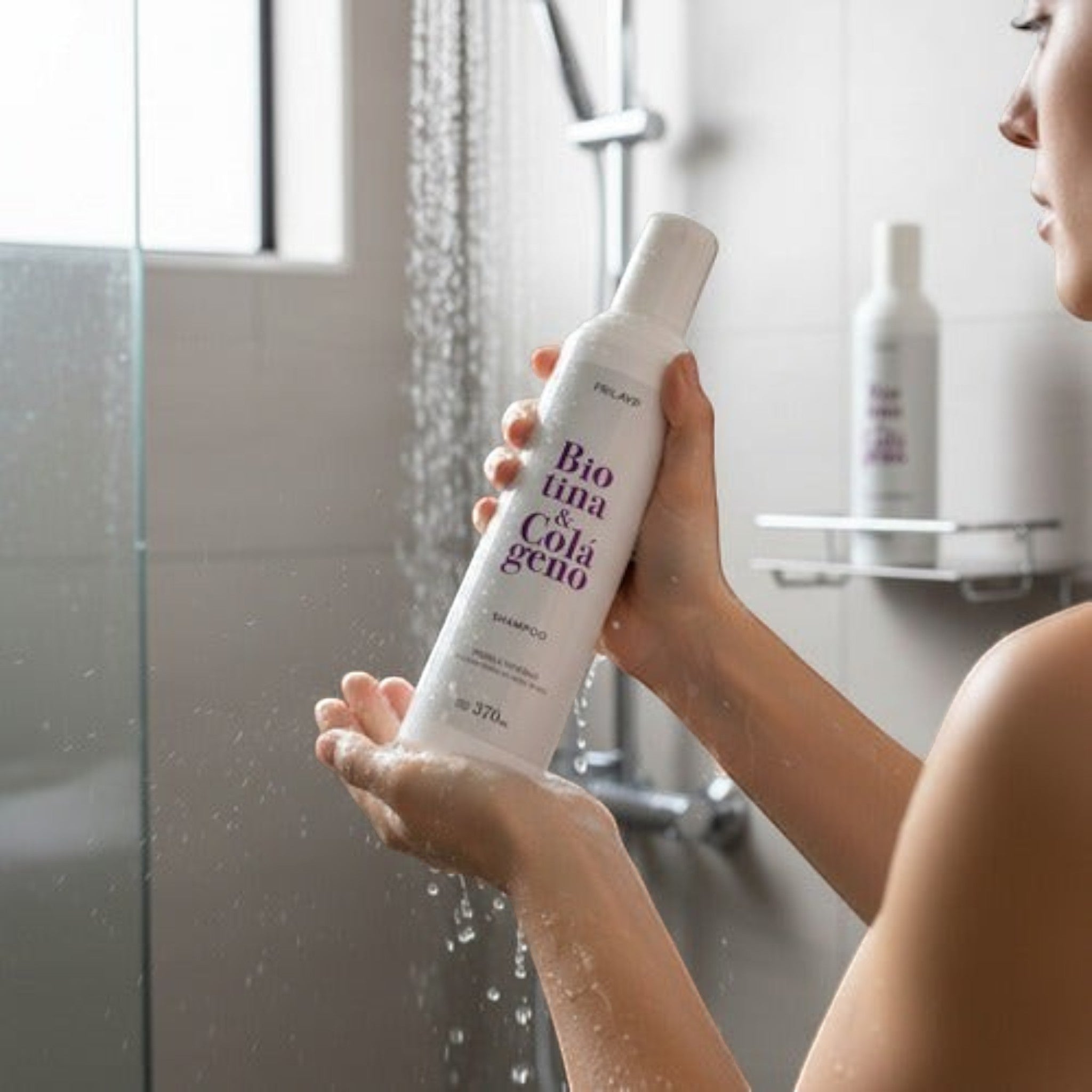 Mujer aplicando shampoo Distriwil Frilayp con biotina y colágeno en la ducha para fortalecer el cabello