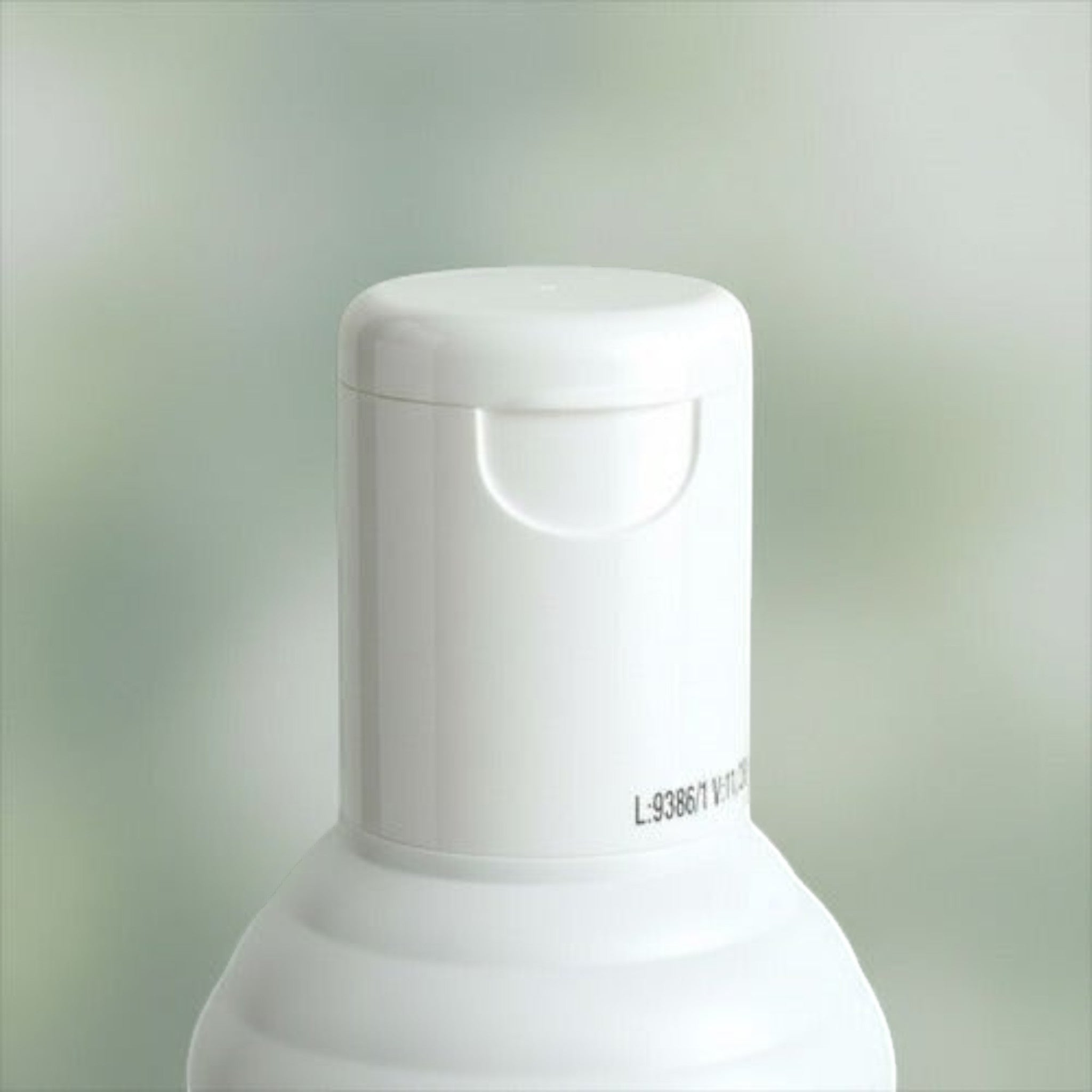 Tapa blanca abatible de botella de shampoo Frilayp Pistacho de Distriwil con detalle de lote impreso