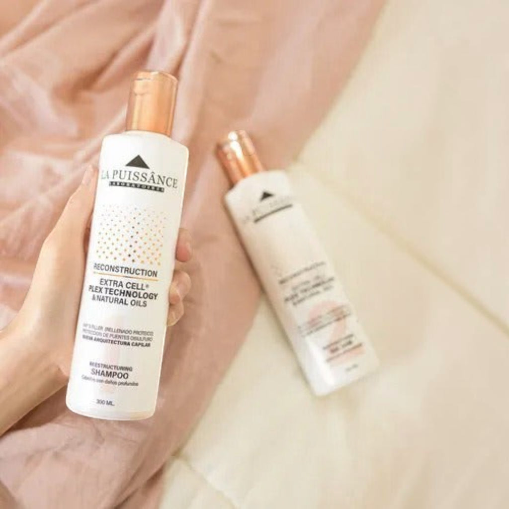 Kit Distriwil La Puissance Extra Cell con shampoo y acondicionador reparadores en envases blancos sobre tela rosa