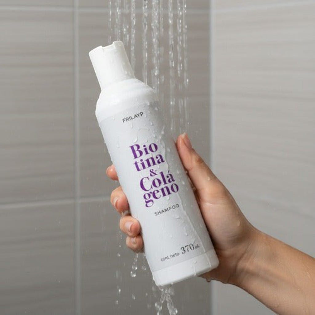 Mano sosteniendo botella de Shampoo Frilayp Biotina y Colágeno bajo la ducha para fortalecer el cabello