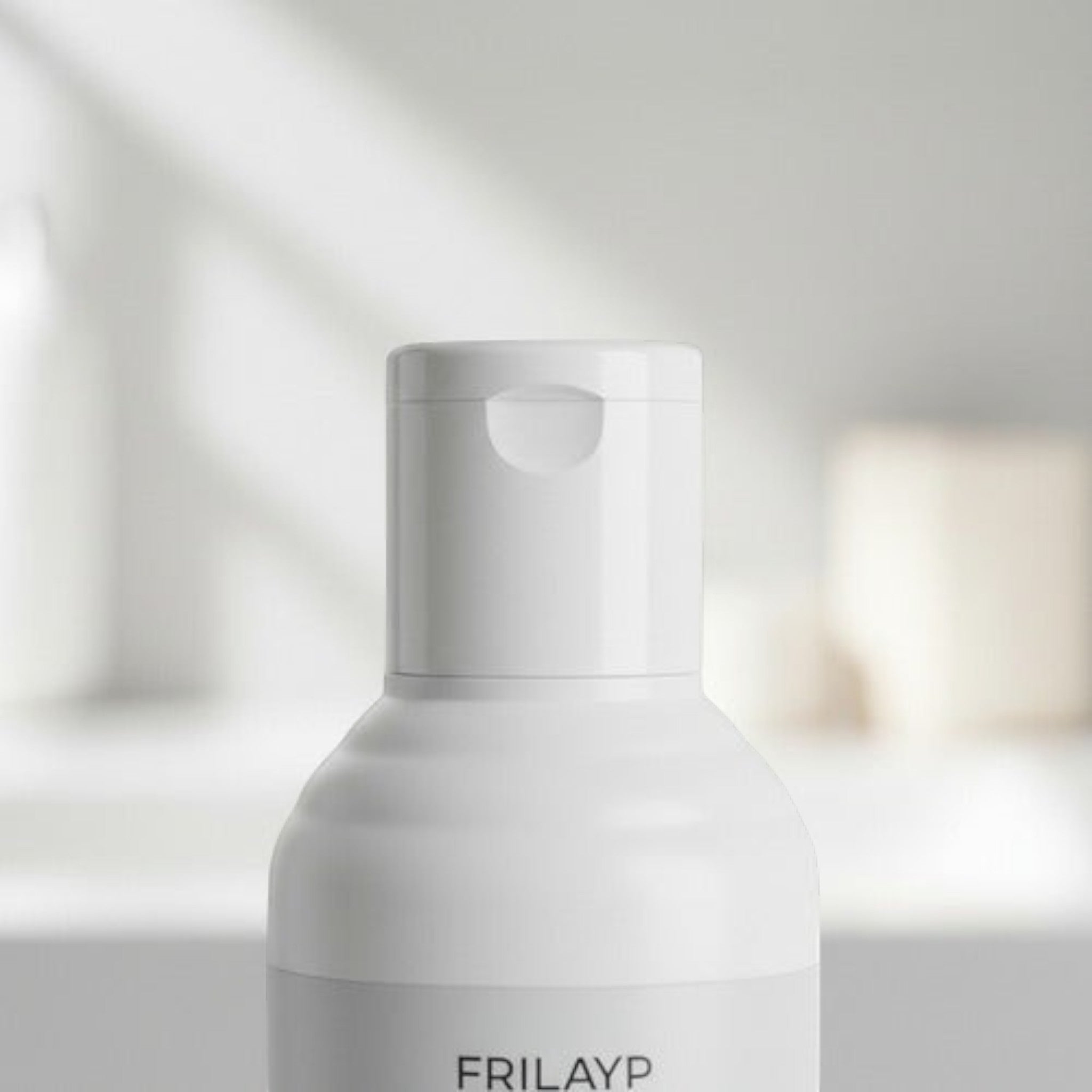 Envase de shampoo Distriwil Frilayp con biotina y colágeno, diseño minimalista en color blanco con tapa abatible